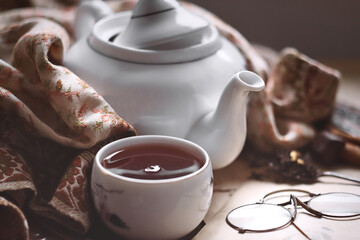 Cozy winter day at home with a cup of hot coffee or tea, dark chocolate, fresh letters and newspapers and granny's coat