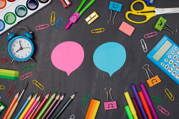 Giving comments and opinion concept. Top above overhead view photo of colorful stationery around two pink and blue bubbles isolated on blackboard