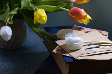 Something old, something new and something blue - bright bouquet of spring tulip flowers, old letters and blue book