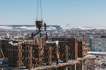 Construction site with crane with blue sky background.Construction of a multi-storey building in the background of the city. View from a height.Pour concrete.