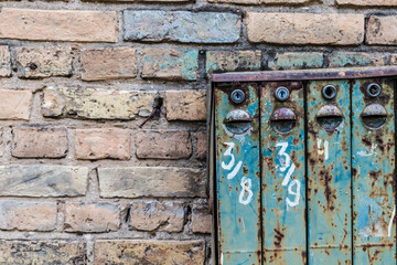 Old Soviet-style mailboxes. Old metal and numbered mailboxes on brick wall.