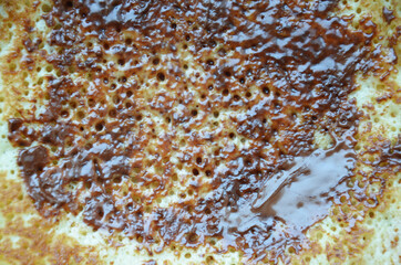 The texture of the surface of a chocolate pancake