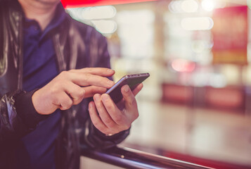 A man writes in her smartphone at the mall