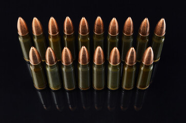 metal cartridges for hunting automatic weapons on a black background with a reflection