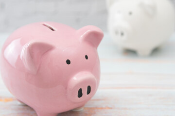 ナチュラルな木目の上に置かれた豚の貯金箱