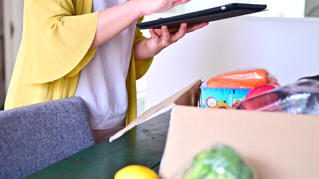ネットスーパーの購入品をタブレットで確認している