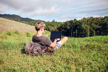 Naklejka na ściany i meble guy in nature with a laptop works 