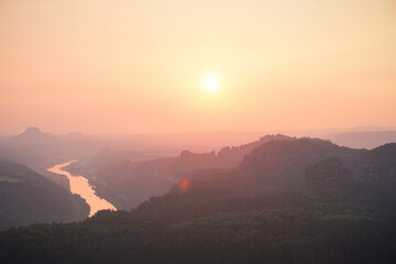 Glowing sunset in Saxon Switzerland, Germany. View to the city Bad Schandau, the Elbe valley and other mountains
