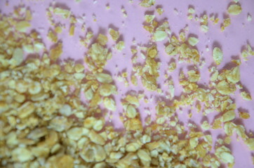 Obraz premium Granola bars, muesli bars or energy bars with oats, dates and nuts on white pink background, close up. Snack for yoga, fitness and sports people, fitness bar, diet concept