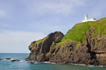 Fototapeta na wymiar 日本海の断崖の上に立つ白い灯台