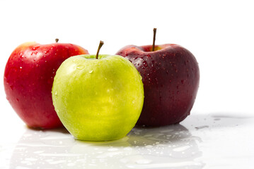 Three apples with water drops. Delicious appetizing beautiful fresh green and red apples on a white background.