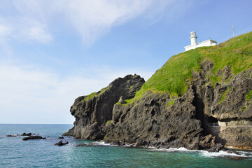 Fototapeta na wymiar 日本海の断崖の上に立つ白い灯台