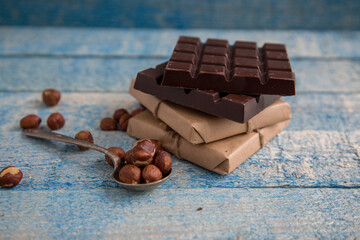 A piece of chocolate with hazelnuts and nuts on a table