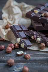 A piece of chocolate with hazelnuts and nuts on a table