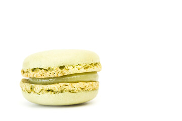 Un macarons verde de pistacho sobre un fondo blanco liso y aislado. Vista de frente y de cerca....