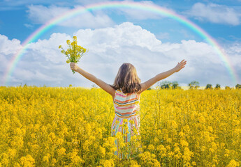 A child in a yellow rainbow field. Selective focus.
