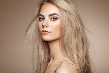 Portrait of beautiful young woman with blonde hair. Girl with long healthy and shiny smooth hair
