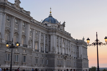 Fototapeta na wymiar Photo of Royal Palace of Madrid with a carousel during Christmas time and sunset