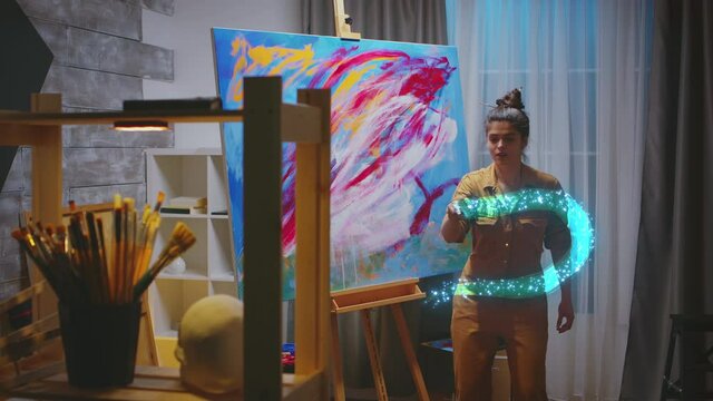 Talented female painter using augmented reality to create light painting on virtual canvas. 3D animation visual effect