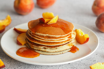 Pancakes with apricot jam and peaches. Pancakes on a plate. Tasty breakfast