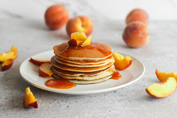 Pancakes with apricot jam and peaches. Pancakes on a plate. Tasty breakfast