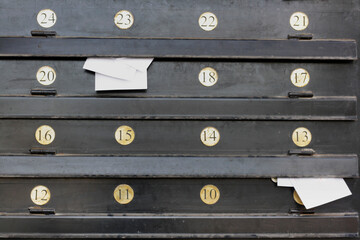 Metal post boxes on the wall and envelopes in it