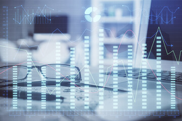 Financial chart hologram with glasses on the table background. Concept of business. Double exposure.
