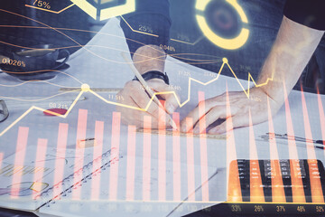 Double exposure of man writing on paper with forex graph.