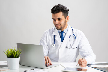 Young arab internist working at computer