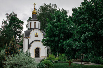 Fototapeta na wymiar Small church in the garden with green trees