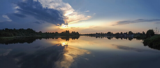 Beautiful panoramic view of sunset over the lake and reflections in the water