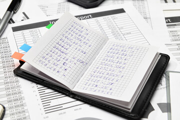 Top view of office employee's desk - work with financial reports, analysis and accounting, tables and graphs, various office items for bookkeeping