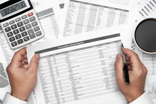 Top view of businessman working with financial statements. Modern black office desk with notebook, pencil and a lot of things. Flat lay table layout.