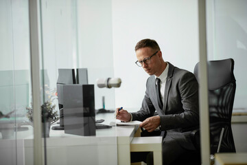 Handsome businessman working in office. Young man preparing for the meeting.	