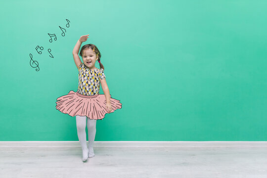 The child is dancing in a hand-drawn ballet tutu. Funny little girl on a turquoise background with a place for text.