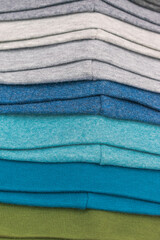 Products from knitted fabric, wool. Color - green, gray, blue. Stitches. Vertical layout. Selective focus. Concept - hats store.