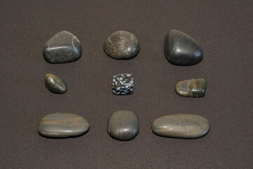 stones laid out in a three by three grid on a dark background