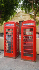 Fototapeta na wymiar Red phone booth a in the ancient city of Valletta, Malta