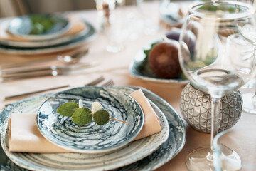 Beautiful elegant table setting with green stylish dishware and silver cutlery