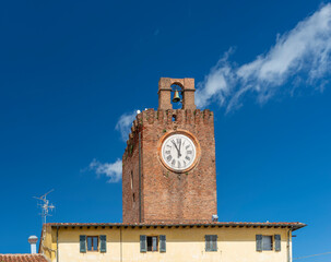 The ancient clock tower marks 11 o'clock on a sunny day in the historic center of Cascina, Pisa,...