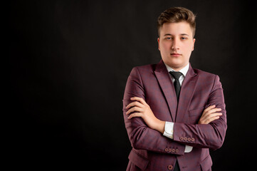 Law student with blond hair dressed in burgundy jacket, white shirt and black tie looking confident