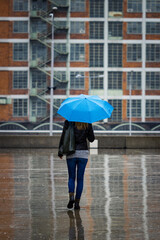 Woman with umbrella walking in city at rain