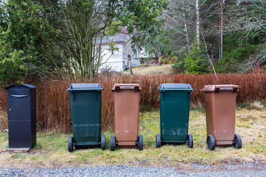 View of typical garbage containers for organic and non-organic garbage sorting near black postbox.