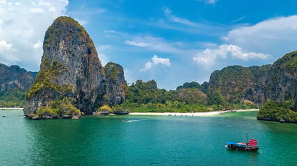 Fototapeta premium Railay beach in Thailand, Krabi province, aerial bird's view of tropical Railay and Pranang beaches with rocks and palm trees, coastline of Andaman sea from above 