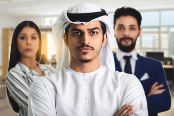 Fototapeta na wymiar SeriousArabic boss with arms folded standing in a modern office with colleagues behind, Arabic Boss With Group Of Business People In, Successful Mix Race Man Leading Businesspeople Team.