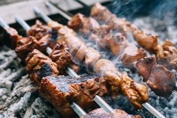 Skewers of pork ribs and chicken on skewers. Grilled meat. Cooking outdoors..
