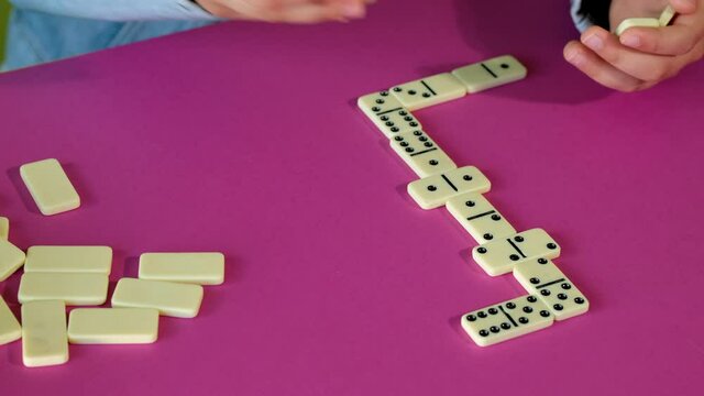 Boy playing domino while spending time at home. Children are play board games.