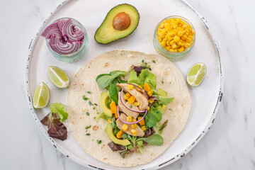 Fresh tortilla wraps with chicken, mushrooms and fresh vegetables on wooden board