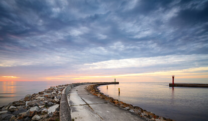 Panoramic view of rocky pier at the entrance to the harbor at sunset.