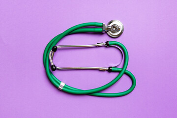 Top view of green stethoscope on colorful background. Medical diagnosis tool concept